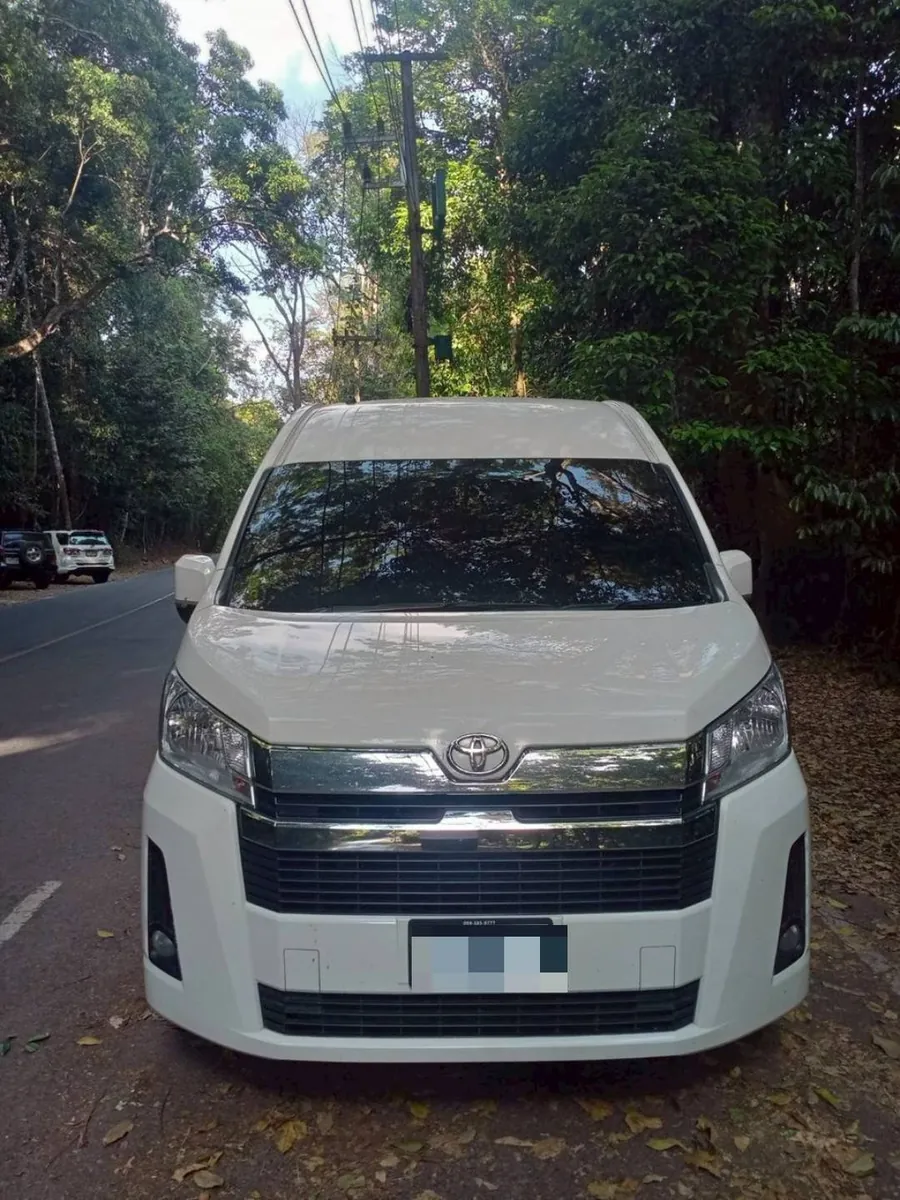 รถตู้ Toyota Commuter สีขาวของ AMT Service & Tour จอดรอรับลูกค้า